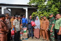 Penjabat (Pj) Bupati Aceh Barat, Azwardi, AP, MSi, menyerahkan bantuan. Foto Ist 